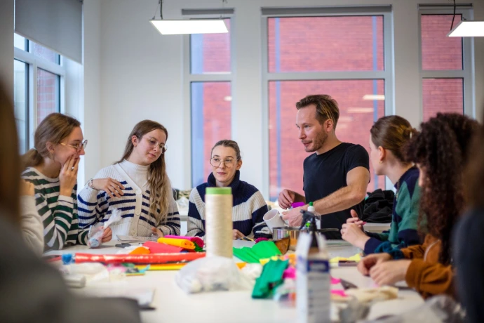Tutor talking with students during a textile design workshop