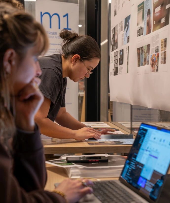 Étudiantes consultant des planches de projets en design graphique