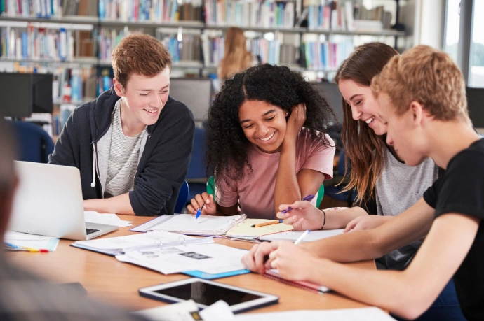 Étudiants souriants travaillant ensemble en bibliothèque
